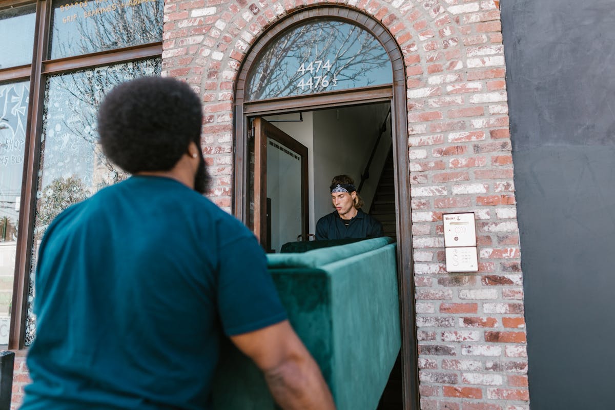 Crew carrying a sofa through a doorway